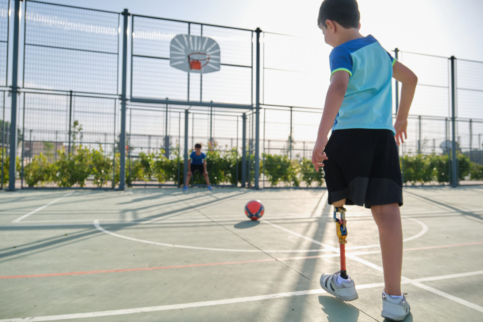 child with a prosthetic leg playing soccer