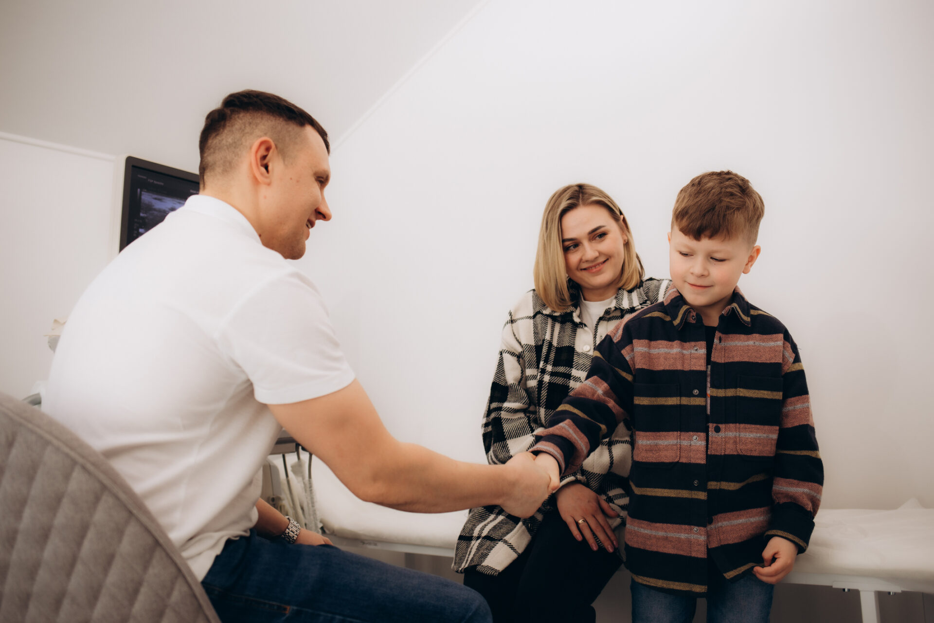 physical therapist shakes hands with a young boy